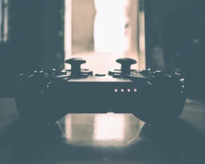 A game controller silhouetted on a table in a dim room