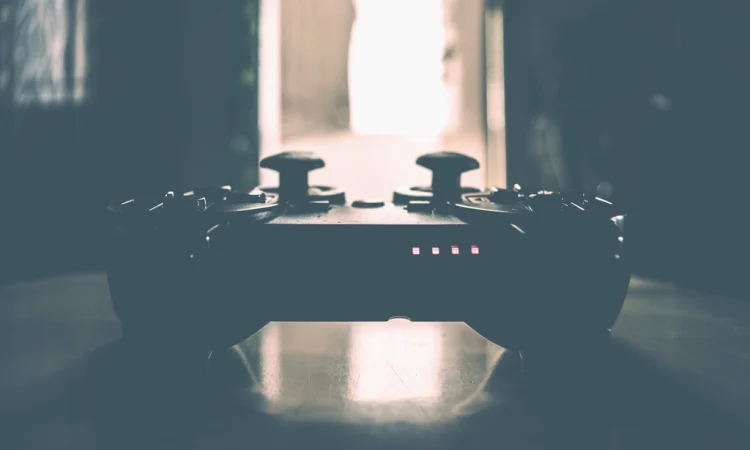 A game controller silhouetted on a table in a dim room
