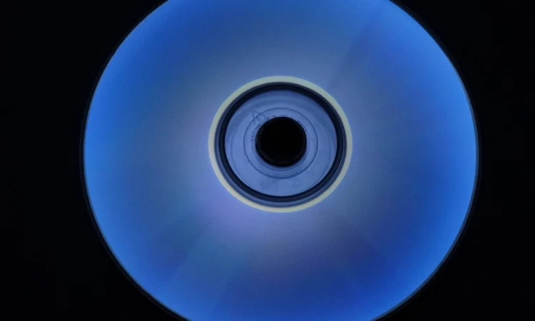 An optical disc glowing blue against a black background