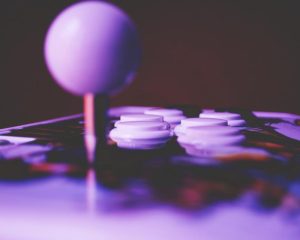 An arcade joystick and buttons lit in purple
