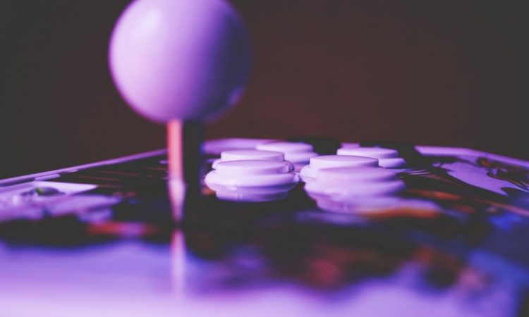 An arcade joystick and buttons lit in purple