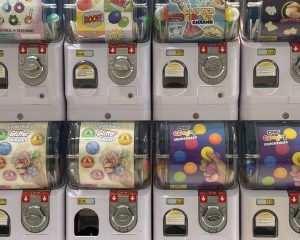 Rows of capsule toy vending machines with colorful prize displays