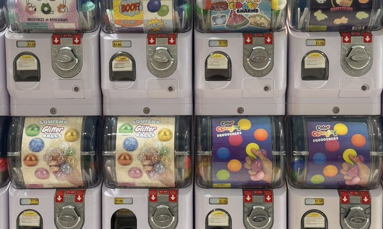 Rows of capsule toy vending machines with colorful prize displays