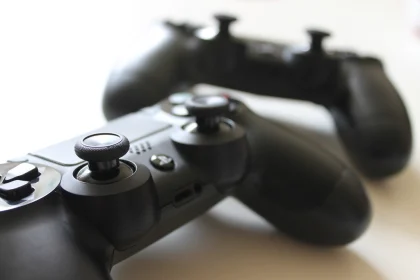 Two black game controllers resting on a white table
