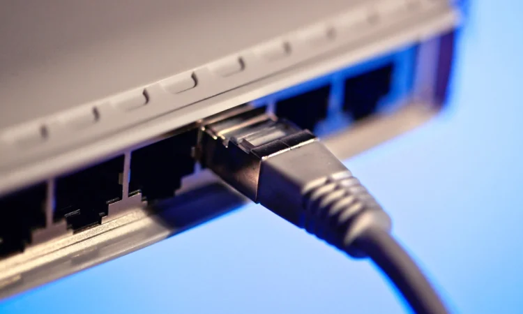 An Ethernet cable plugged into a port on the back of a router